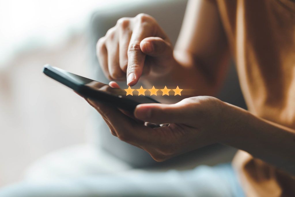 Person typing on mobile smart phone with 5 star rating overlay